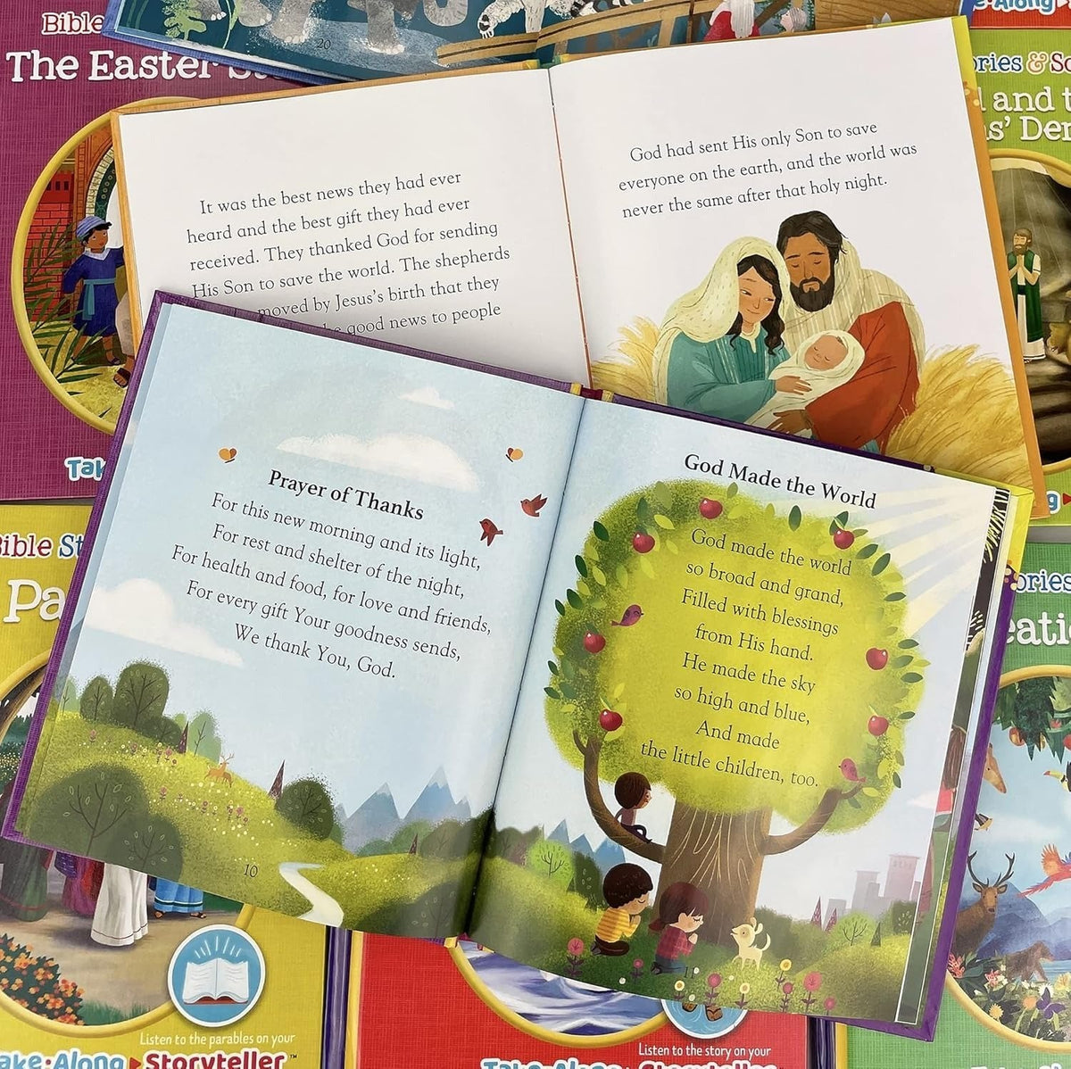 An open children's Bible with colorful illustrated pages showing the story of creation and a prayer of thanks, displayed on top of other children's books.